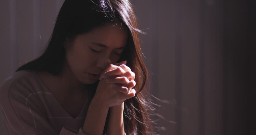 Християнка молиться в темряві.